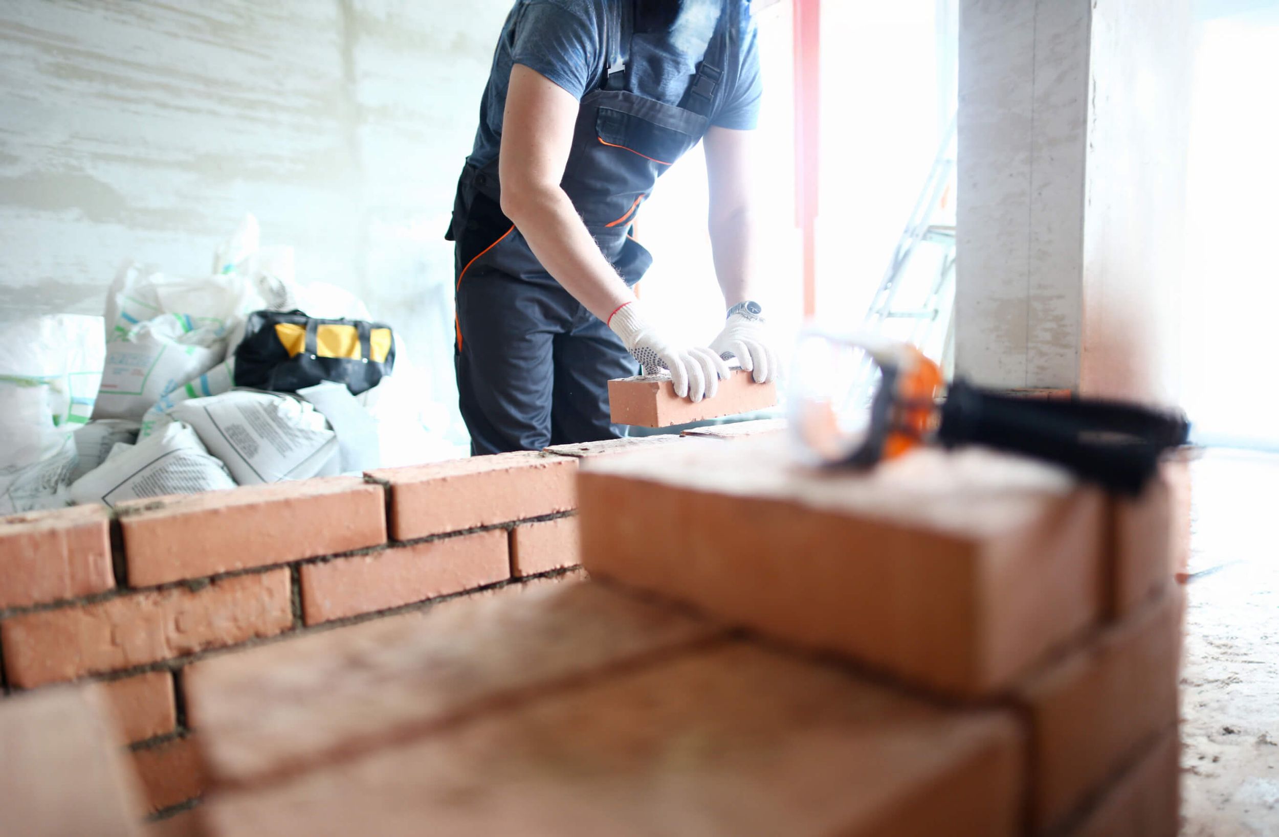 Ein Bauarbeiter verlegt eine Mauer